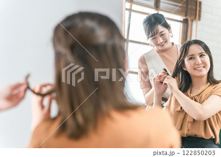 美容室・ヘアサロンで髪型を相談するアジア人女性の客とカウンセリングする美容師・スタイリスト 美容室・ヘアサロンで髪型を相談するアジア人女性の客とカウンセリングする美容師・スタイリスト 122850203