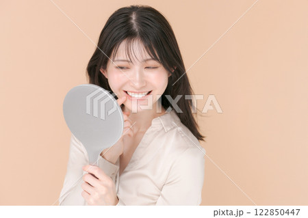 鏡を見て微笑む女性 122850447