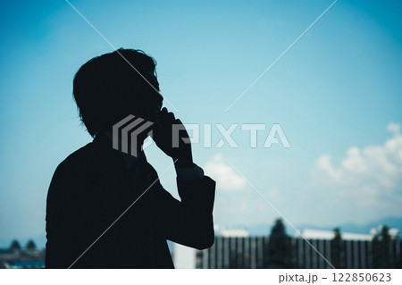 電話・通話するビジネスマンのシルエット・影 122850623