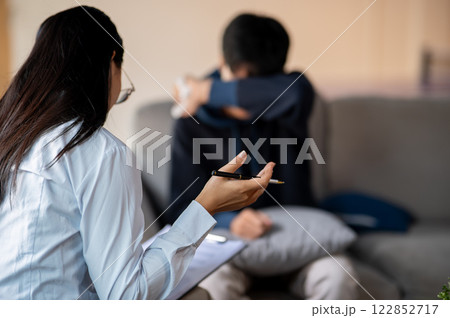 A back view of a female psychologist talking with her patient, offering advice and showing empathy. 122852717