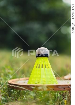 Badminton racket and shuttlecock lie on green grass. Outside recreation and fresh air. Healthy lifestyle nature connection sport summer activities. Stress relief hobby Badminton racket and shuttlecock lie on green grass. Outside recreation and fresh air. Healthy lifestyle nature connection sport summer activities. Stress relief hobby 122854721