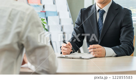 男性顧客を接客・商談・カウンセリングする若いアジア人ビジネスマン（保険・自動車） 122855583