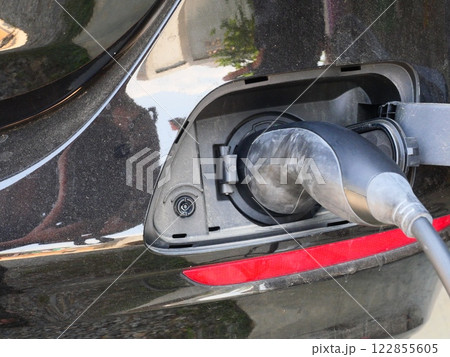 Power cable pump plug in charging power to black color electric vehicle car, Modern automotive and transportation technology Power cable pump plug in charging power to black color electric vehicle car, Modern automotive and transportation technology 122855605