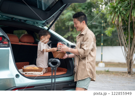 An innocent little Asian boy is in the trunk of their car, excited for their camping adventure. 122855949