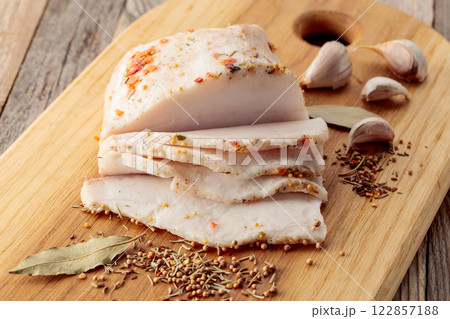 Salted lard with spices on a cutting board. 122857188