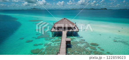 Tropical Overwater Bungalow Floating Above Vibrant Turquoise Coral Reef Paradise 122859023
