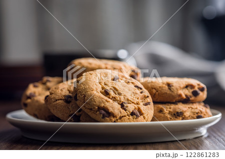 Chocolate chip cookies on plate on wooden table. Chocolate chip cookies on plate on wooden table. 122861283