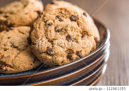 Chocolate chip cookies on plate on wooden table. Chocolate chip cookies on plate on wooden table. 122861285