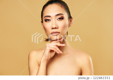 Beauty portrait of young woman with healthy skin and natural makeup over beige background Beauty portrait of young woman with healthy skin and natural makeup over beige background 122861551