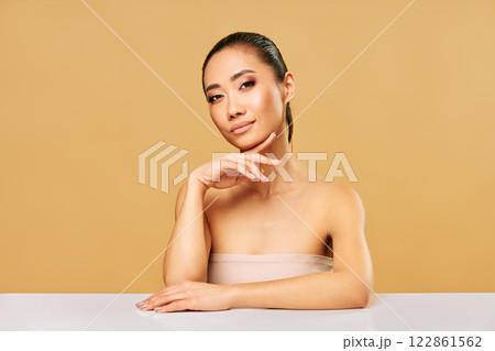 Beauty portrait of young woman with healthy skin and natural makeup over beige background Beauty portrait of young woman with healthy skin and natural makeup over beige background 122861562
