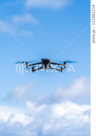青空を飛行するドローン 122862214