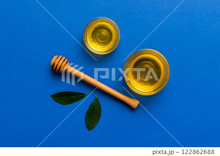 Honey jar with wooden honey dipper on white background top view with copy space. Delicious honey bottle 122862688