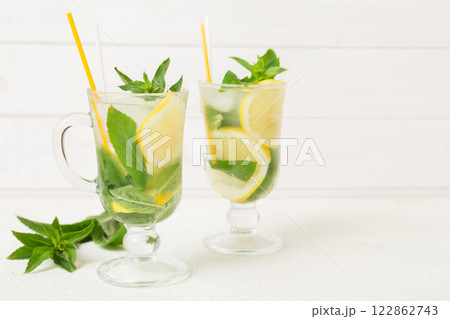 Mojito cocktail. Refreshing mojito cocktail with lime, lemon and mint in a tall glass with a stick 122862743