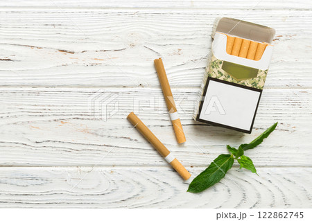 Pack of menthol cigarettes and fresh mint on colored table, Menthol cigarettes top view flat lay Pack of menthol cigarettes and fresh mint on colored table, Menthol cigarettes top view flat lay 122862745