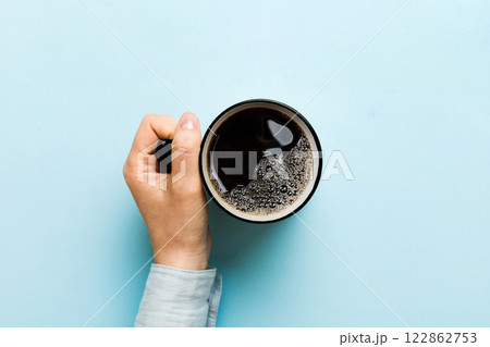 Minimalistic style woman hand holding a cup of coffee on Colored background. Flat lay, top view cappuccino cup. Empty place for text, copy space. Coffee addiction. Top view, flat lay Minimalistic style woman hand holding a cup of coffee on Colored background. Flat lay, top view cappuccino cup. Empty place for text, copy space. Coffee addiction. Top view, flat lay 122862753
