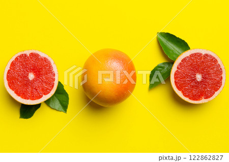 fresh Fruit grapefruit with Juicy grapefruit slices on colored background. Top view. Copy Space. creative summer concept. Half of citrus in minimal flat lay with copy space 122862827