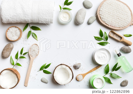 Coconut with jars of coconut oil and cosmetic cream on colored background. Top view. Free space for your text. Natural spa coconut cosmetics and organic treatment concept Coconut Spa composition 122862896