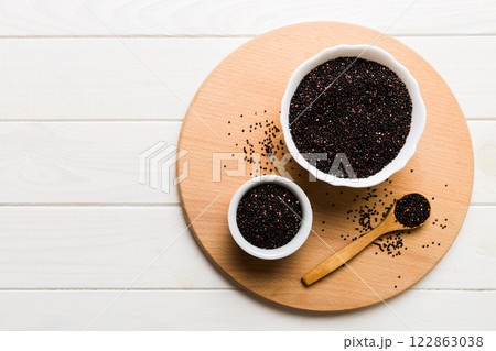 quinoa seeds in bowl and spoon on colored background. Healthy kinwa in small bowl. Healthy superfood 122863038