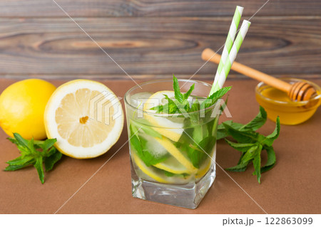 Mojito cocktail. Refreshing mojito cocktail with lime, lemon and mint in a tall glass with a stick Mojito cocktail. Refreshing mojito cocktail with lime, lemon and mint in a tall glass with a stick 122863099