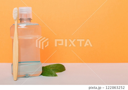 Mouthwash and fresh mint on colored background, top view with copy space for text Mouthwash and fresh mint on colored background, top view with copy space for text 122863252