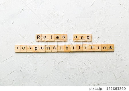 roles and responsibilities word written on wood block. roles and responsibilities text on table, concept 122863260