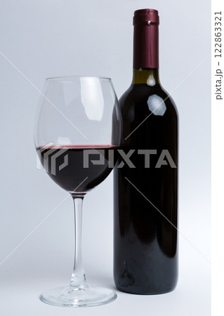 Glass of red wine and a bottle on colored table. Flat lay, top view wth copy space 122863321