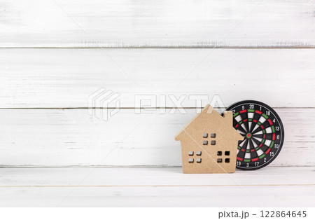 Wooden House with Dartboard on White Wooden Background Representing Real Estate Targeting 122864645