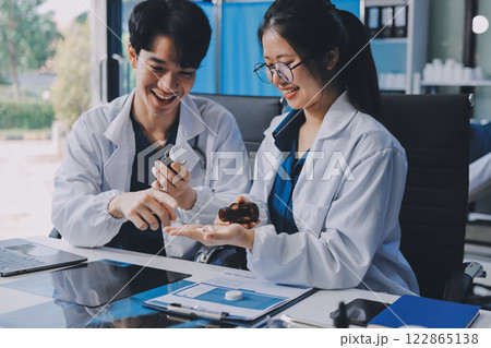 Positive doctor working on laptop in medical office, portrait. 122865138