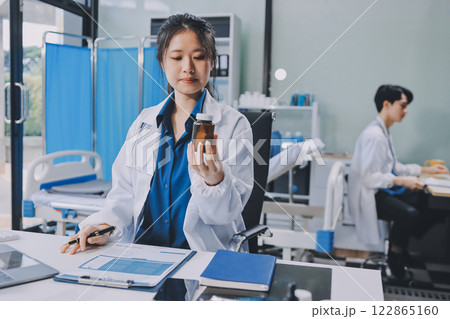 Positive doctor working on laptop in medical office, portrait. Positive doctor working on laptop in medical office, portrait. 122865160