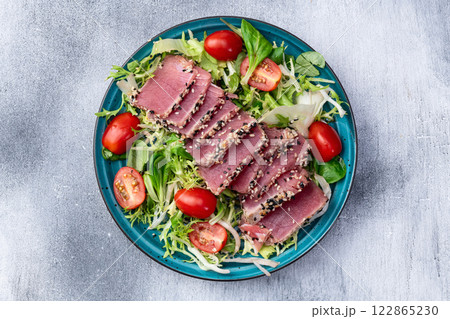 Salad with raw tuna , sesame and cherry tomatoes photography . Top view Salad with raw tuna , sesame and cherry tomatoes photography . Top view 122865230
