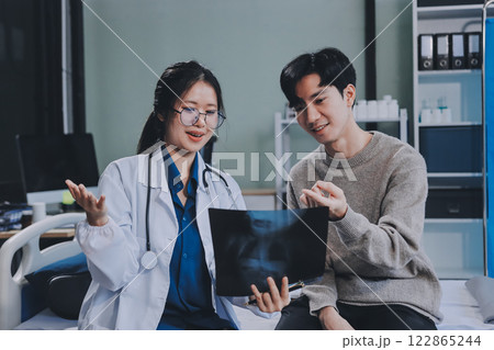 Female physician reads medical history while visiting her patient 122865244