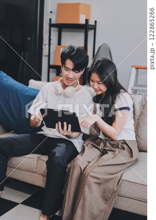 Smiling couple unpacking boxes in new house 122865266