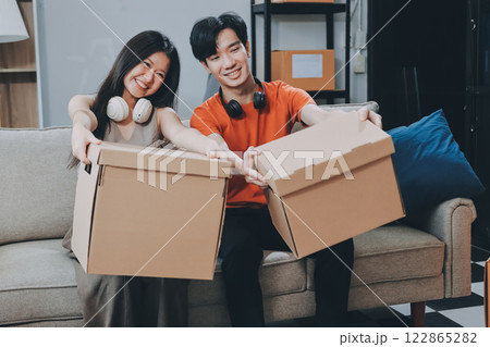 Smiling couple unpacking boxes in new house 122865282