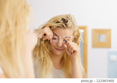 Woman feeling tired in bathroom Woman feeling tired in bathroom 122865468