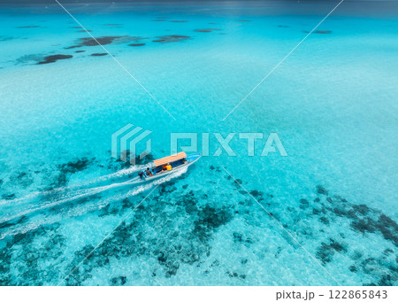 Aerial view of floating boat in clear turquoise water in summer 122865843
