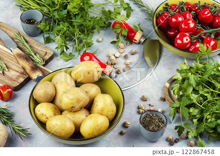 Raw potato and red tomatoes on a table Raw potato and red tomatoes on a table 122867458