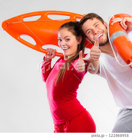 Happy lifeguard couple with equipment Happy lifeguard couple with equipment 122868958