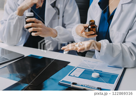 Positive doctor working on laptop in medical office, portrait. Positive doctor working on laptop in medical office, portrait. 122869316