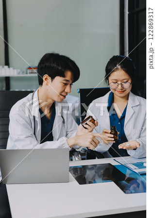 Positive doctor working on laptop in medical office, portrait. Positive doctor working on laptop in medical office, portrait. 122869317