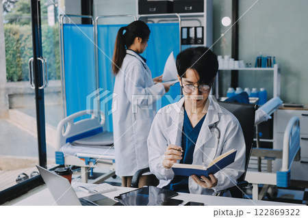 Positive doctor working on laptop in medical office, portrait. Positive doctor working on laptop in medical office, portrait. 122869322