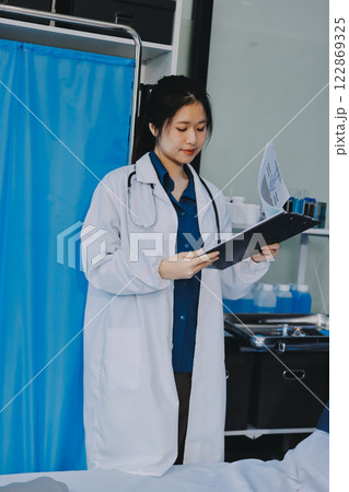 Positive doctor working on laptop in medical office, portrait. Positive doctor working on laptop in medical office, portrait. 122869325