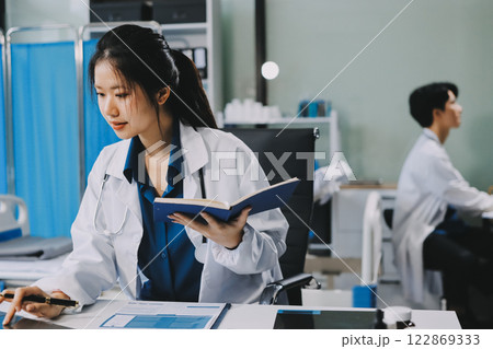 Positive doctor working on laptop in medical office, portrait. Positive doctor working on laptop in medical office, portrait. 122869333