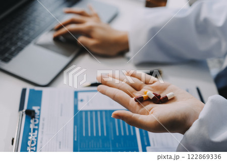 Positive doctor working on laptop in medical office, portrait. 122869336