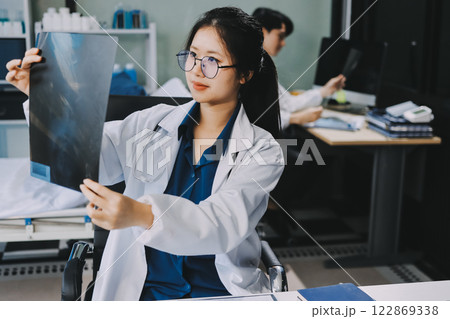 Positive doctor working on laptop in medical office, portrait. Positive doctor working on laptop in medical office, portrait. 122869338