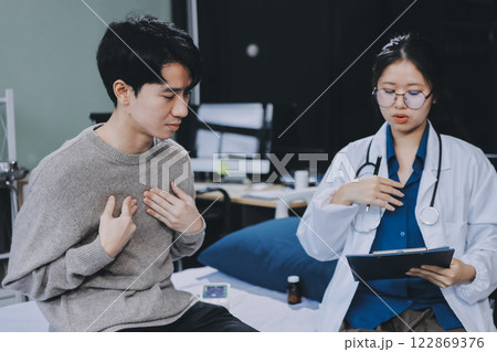 Female physician reads medical history while visiting her patient 122869376