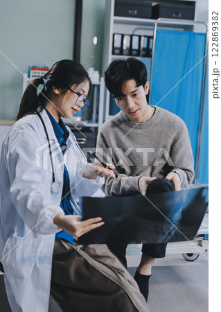 Female physician reads medical history while visiting her patient Female physician reads medical history while visiting her patient 122869382