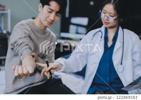 Female physician reads medical history while visiting her patient 122869383