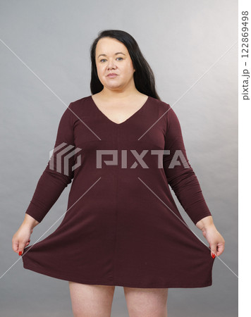 Woman showing size of brown top tunic Woman showing size of brown top tunic 122869498