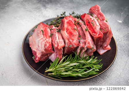Raw Beef Kalbi Short Ribs, fresh meat with bone on plate with thyme. grey background. top view Raw Beef Kalbi Short Ribs, fresh meat with bone on plate with thyme. grey background. top view 122869842
