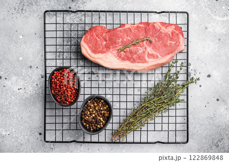 Fresh Raw New York strip beef steak, strip loin with herbs. grey background. top view Fresh Raw New York strip beef steak, strip loin with herbs. grey background. top view 122869848